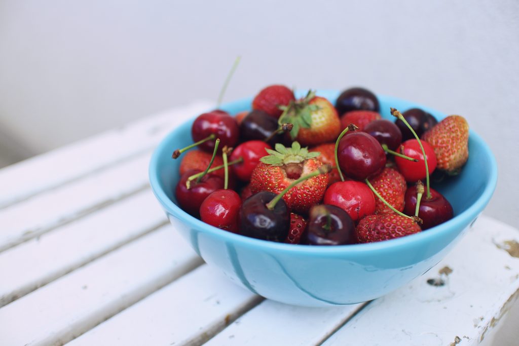 Des fraises et cerises dans un bol